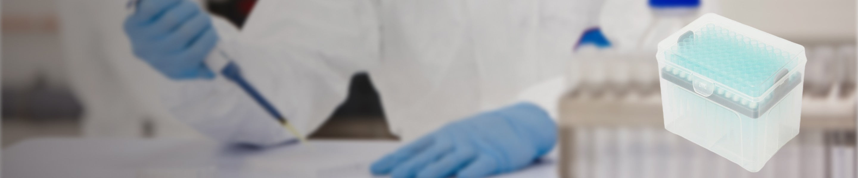 Scientist in protective gear using a pipette to transfer liquid next to a tip box.