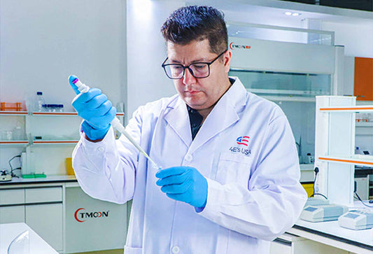 A researcher using a Four E's USA pipette to transfer liquid in a laboratory.