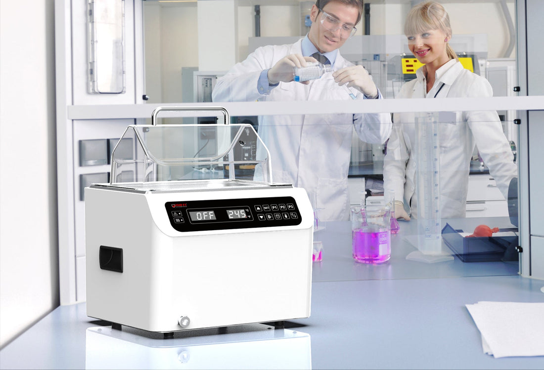 White lab water bath  in foreground with researchers in background.